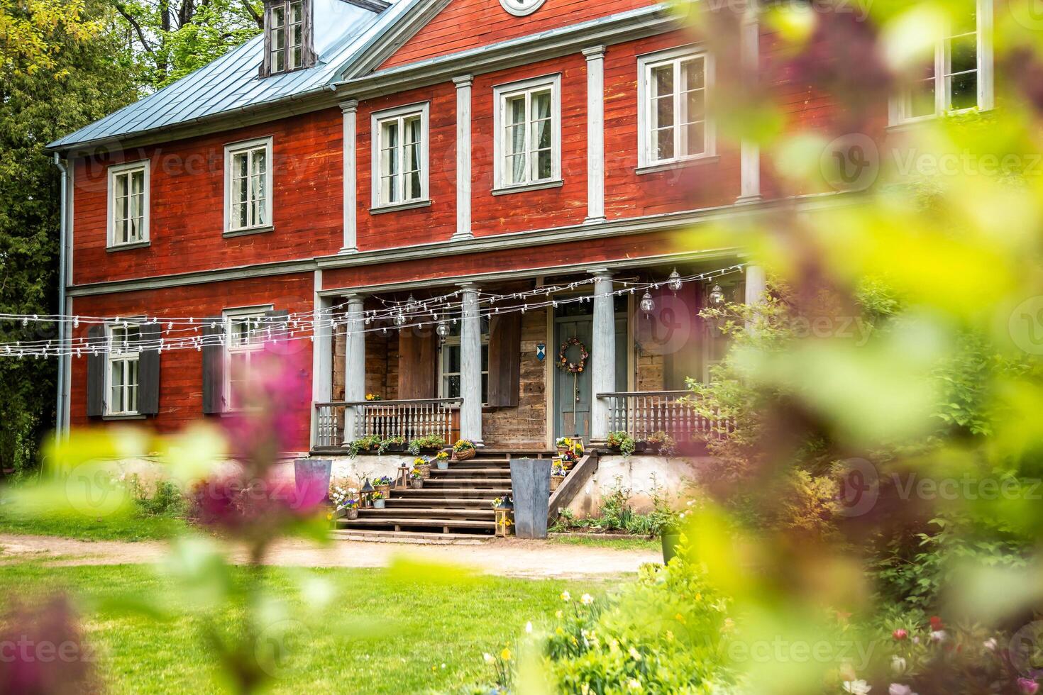Two Story Red Wooden Building with Porch and String Lights photo
