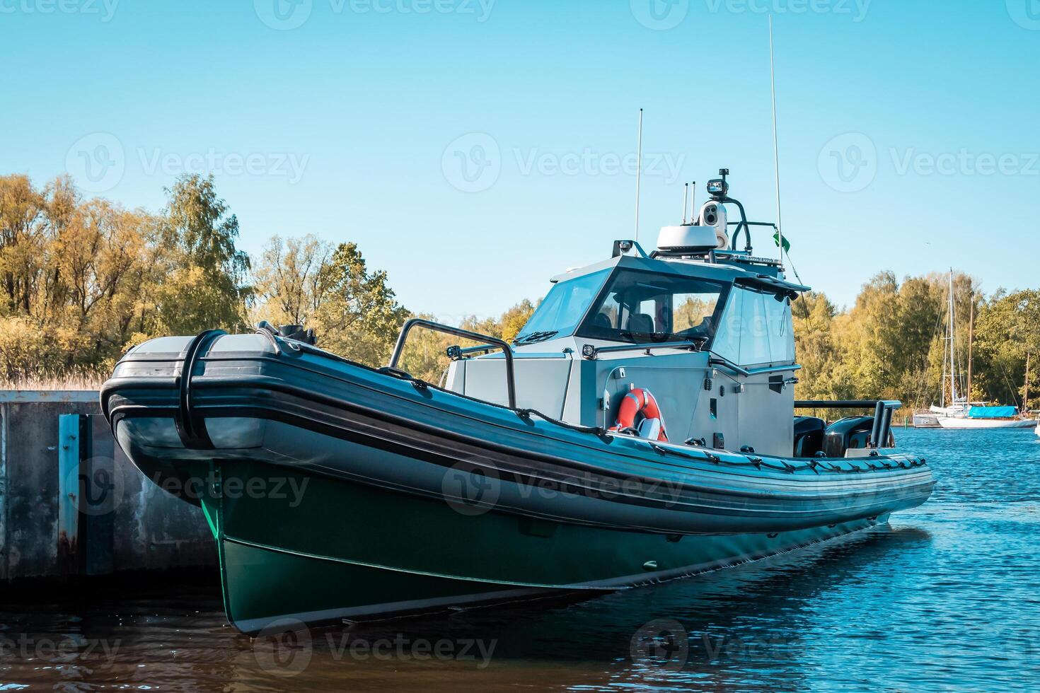Motorized Boat with Green Hull Docked Near Concrete Pier in Autumn photo