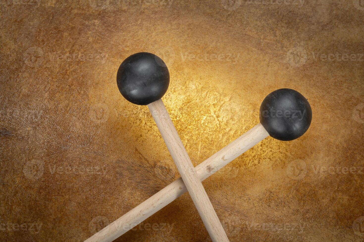 rubber xylophone mallets against backlit drum goat skin photo