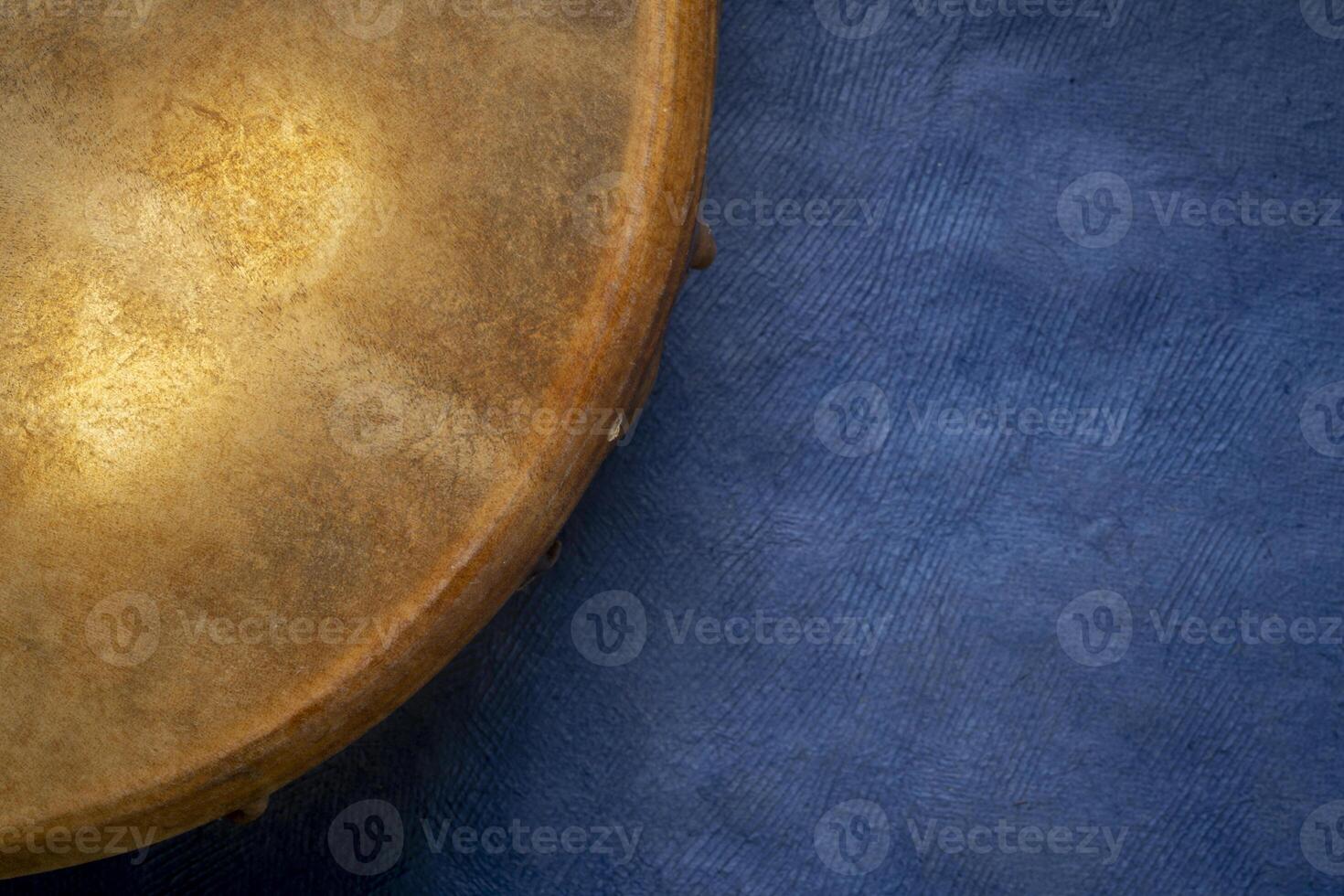 detail of handmade, native American style, shaman frame drum against textured art paper photo