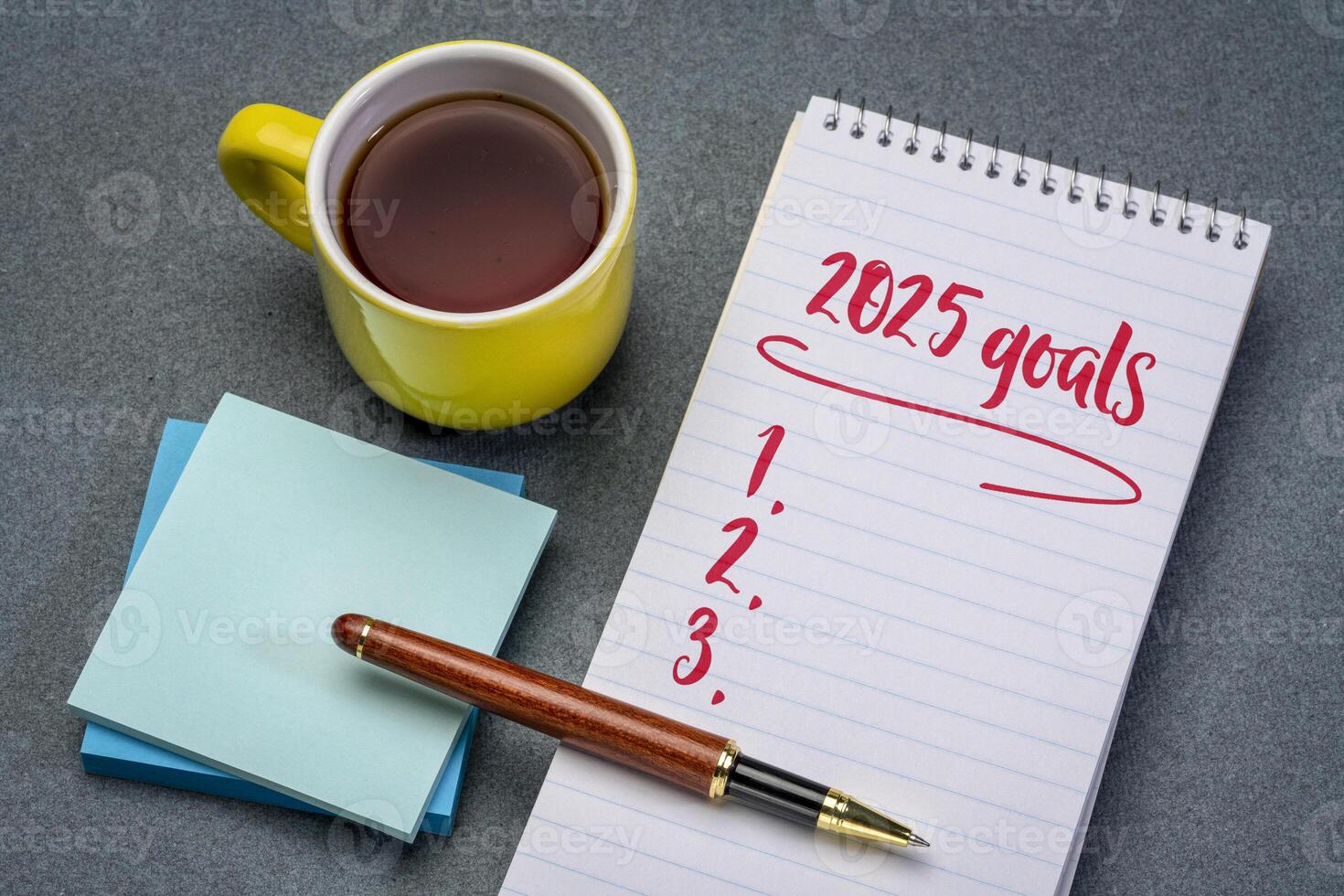 2025 goals list in a notebook with pen and coffee, setting New Year goals and resolutions photo