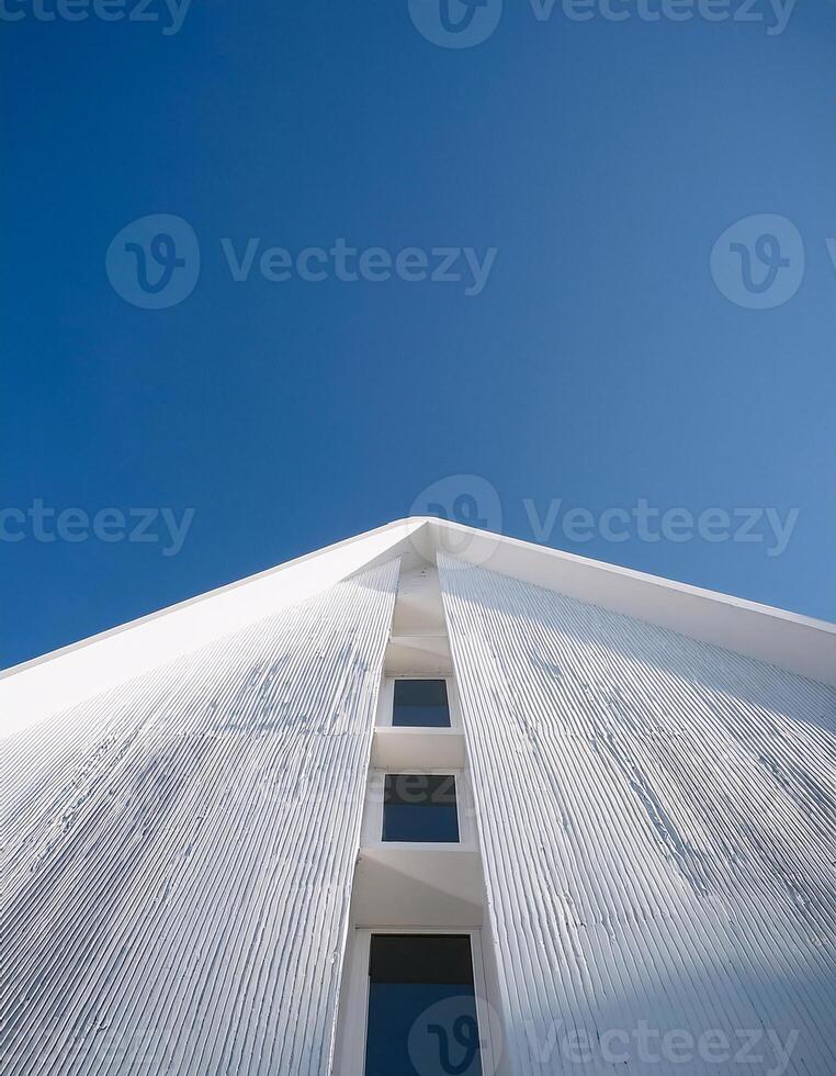 Upward View of a White Building Reaching Toward a Clear Sky photo