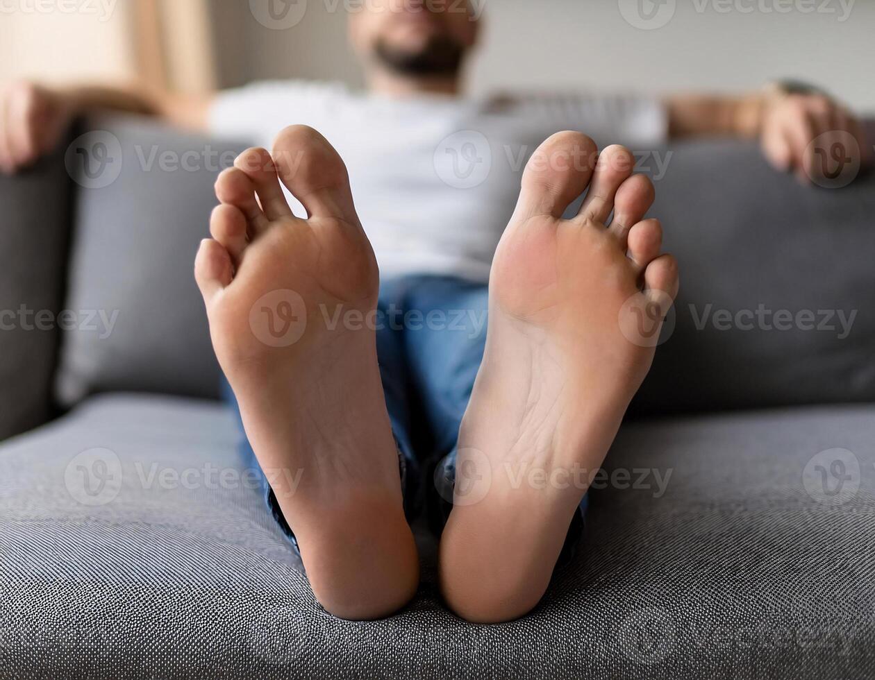 Relaxed Comfort. Close-Up of Man Lying on Grey Couch in Living Room photo