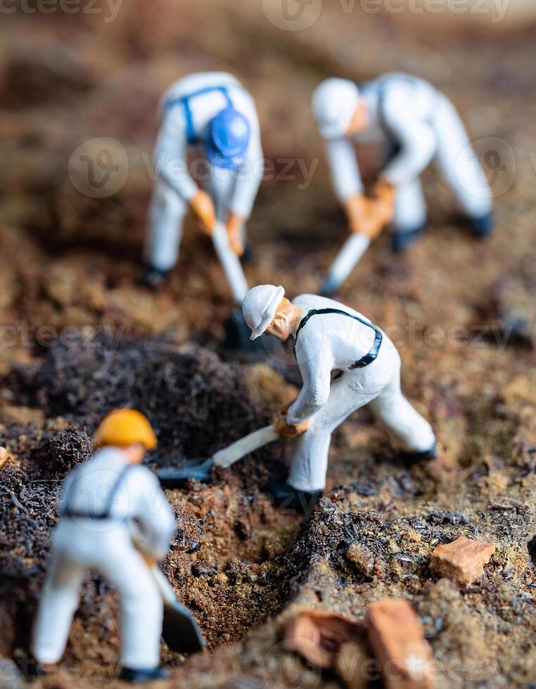 Miniature workers are diligently digging the ground at a construction photo