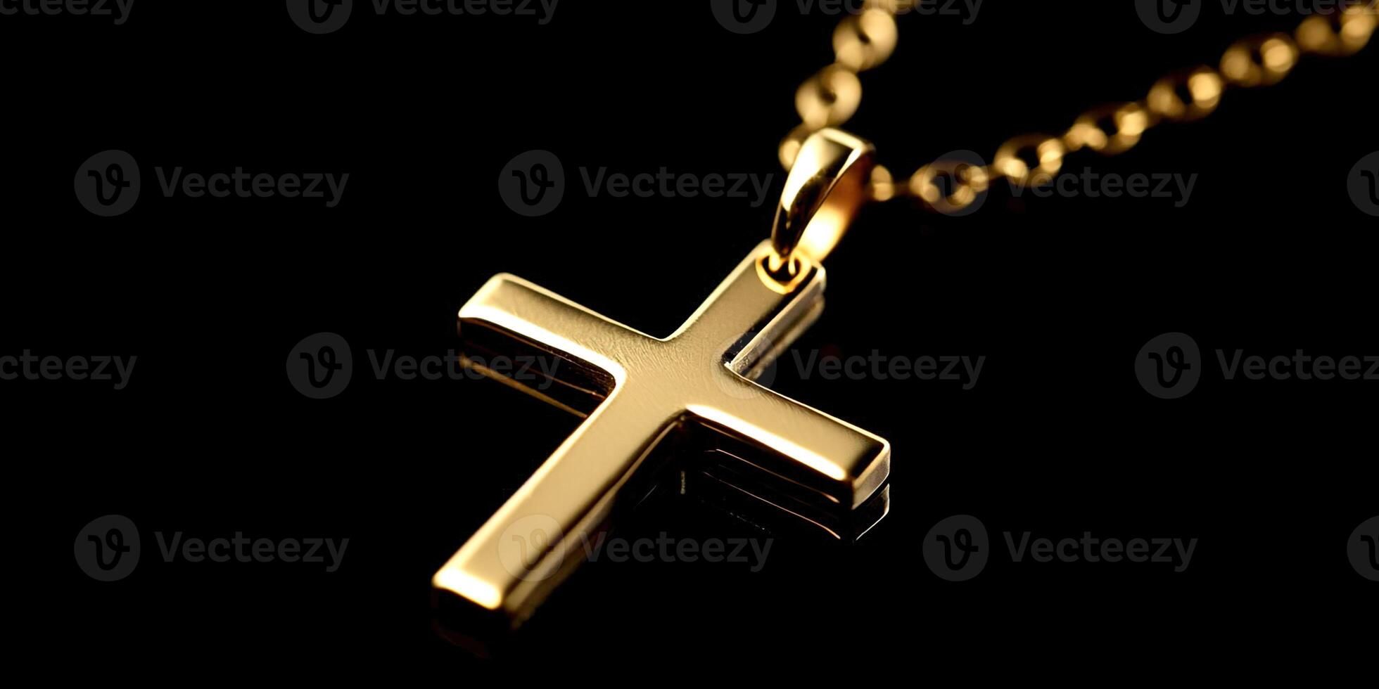 A gold cross pendant is hanging from a chain photo