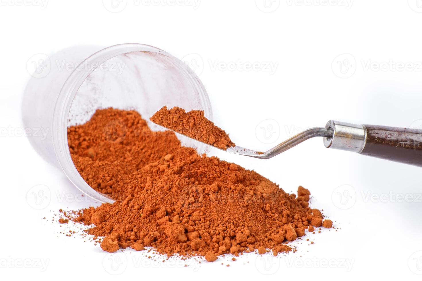 Bright Orange pigment Spice Spilling From Container With Scoop on White Background photo
