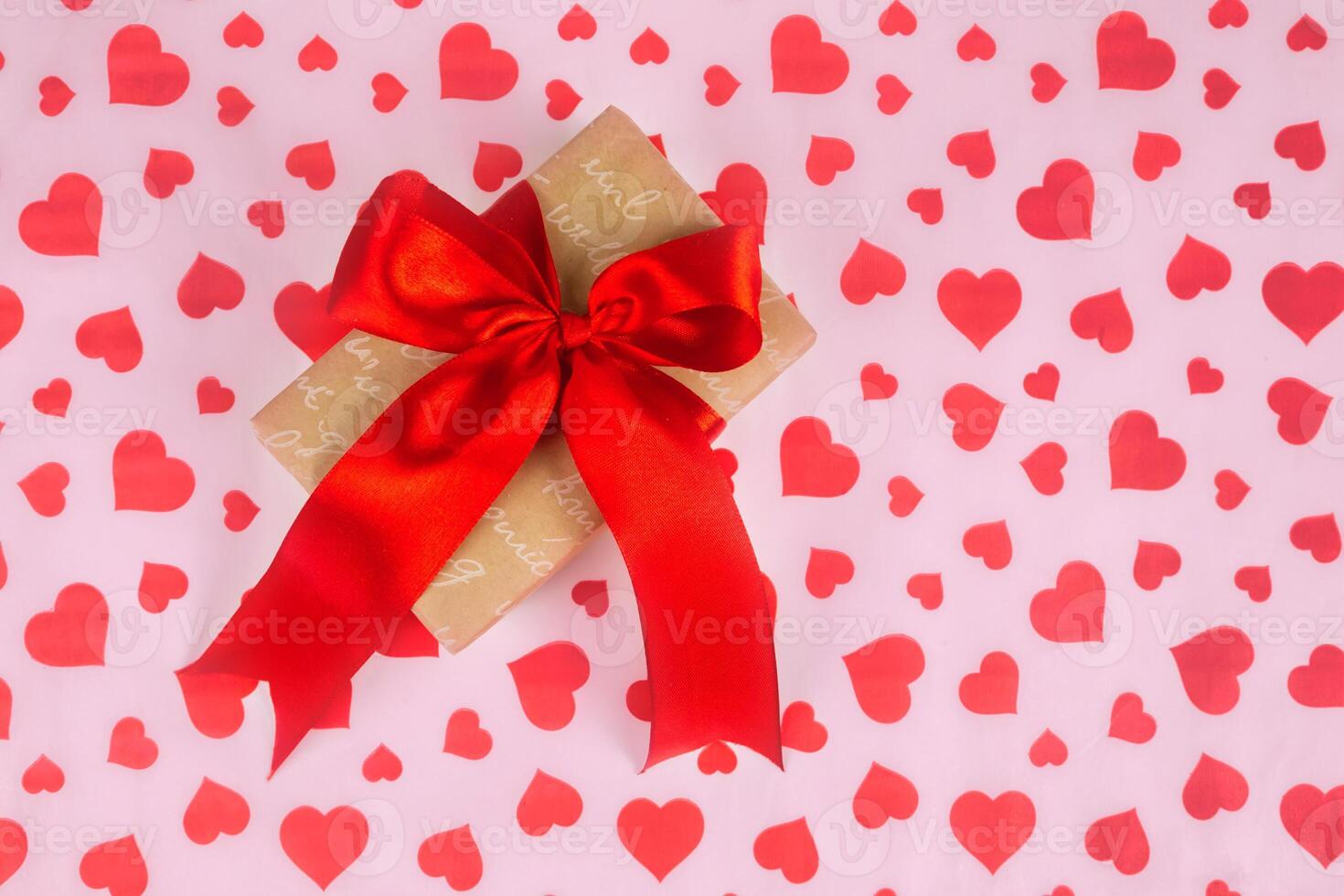 Valentine's Day. Presented as a red ribbon on a pink paper with red hearts photo
