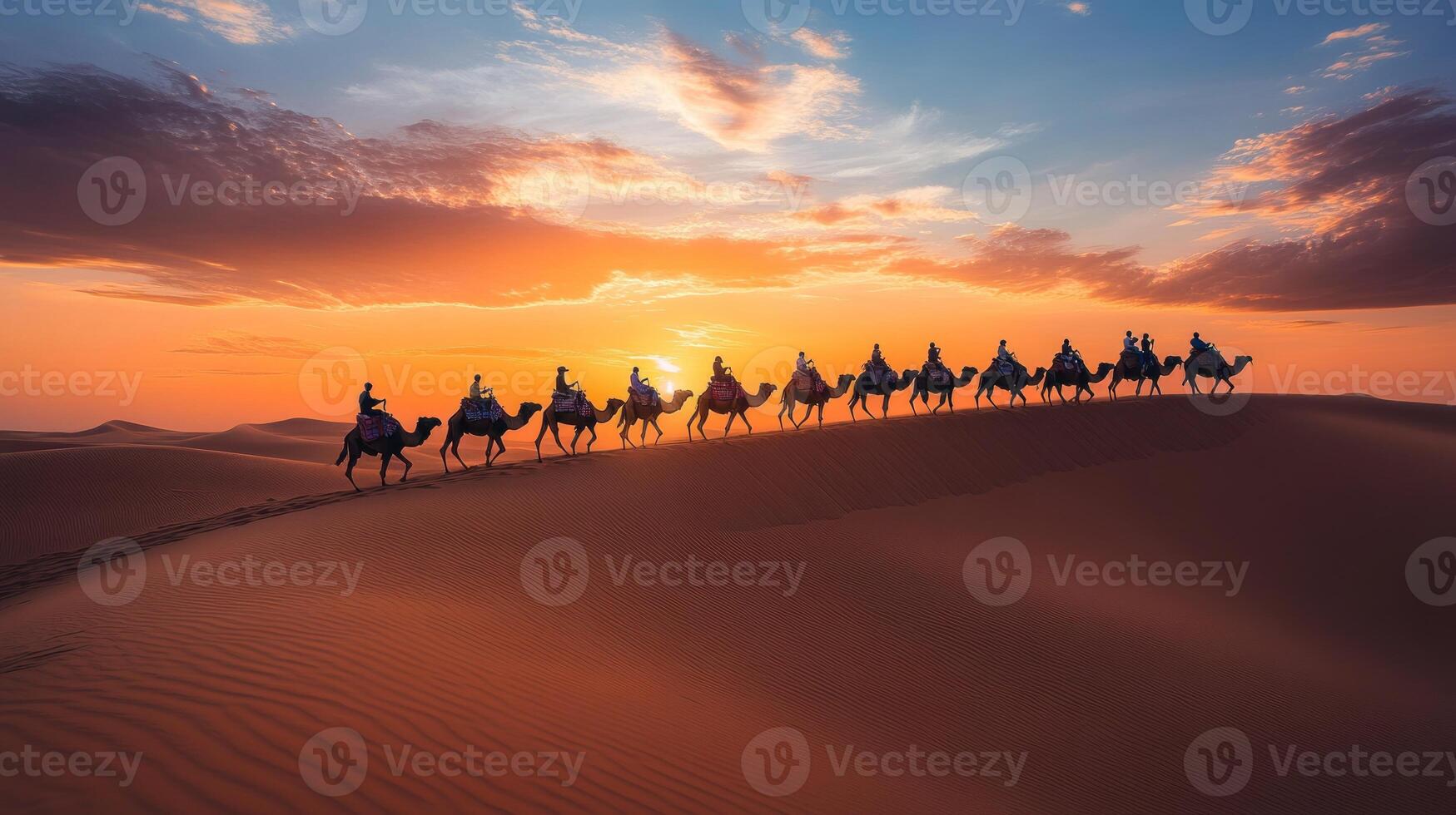 Camel Caravan Crossing Desert Dunes at Sunset. photo
