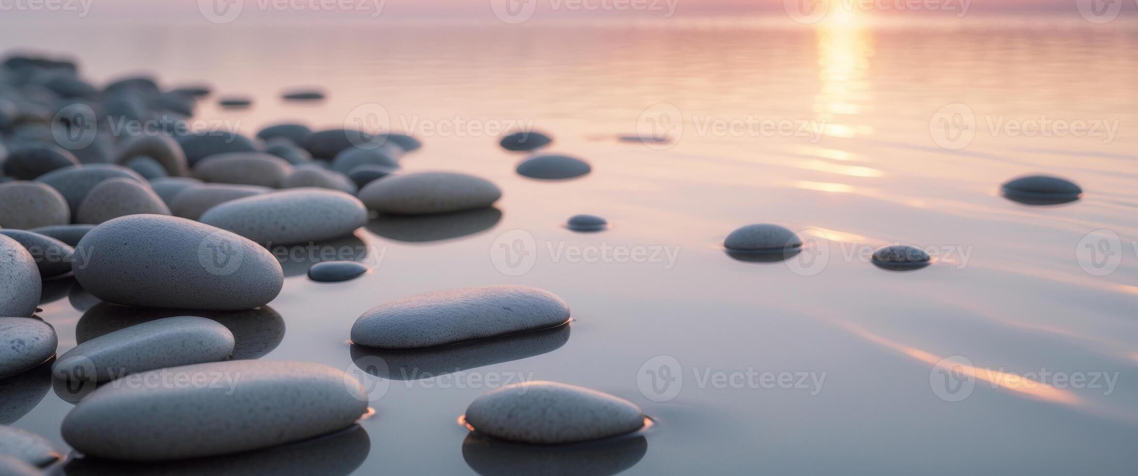 Tranquil sunset reflection on smooth pebbles by the lake photo