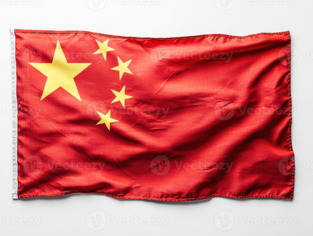 Chinese flag displayed prominently showcasing vibrant colors and symbolic stars against a plain backdrop photo