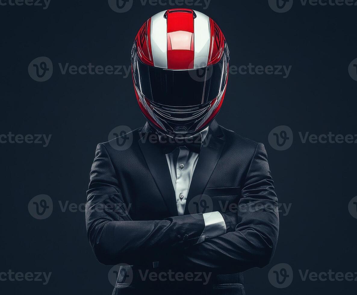 Stylish racer in a suit stands confidently with arms crossed, showcasing a striking red and white helmet photo