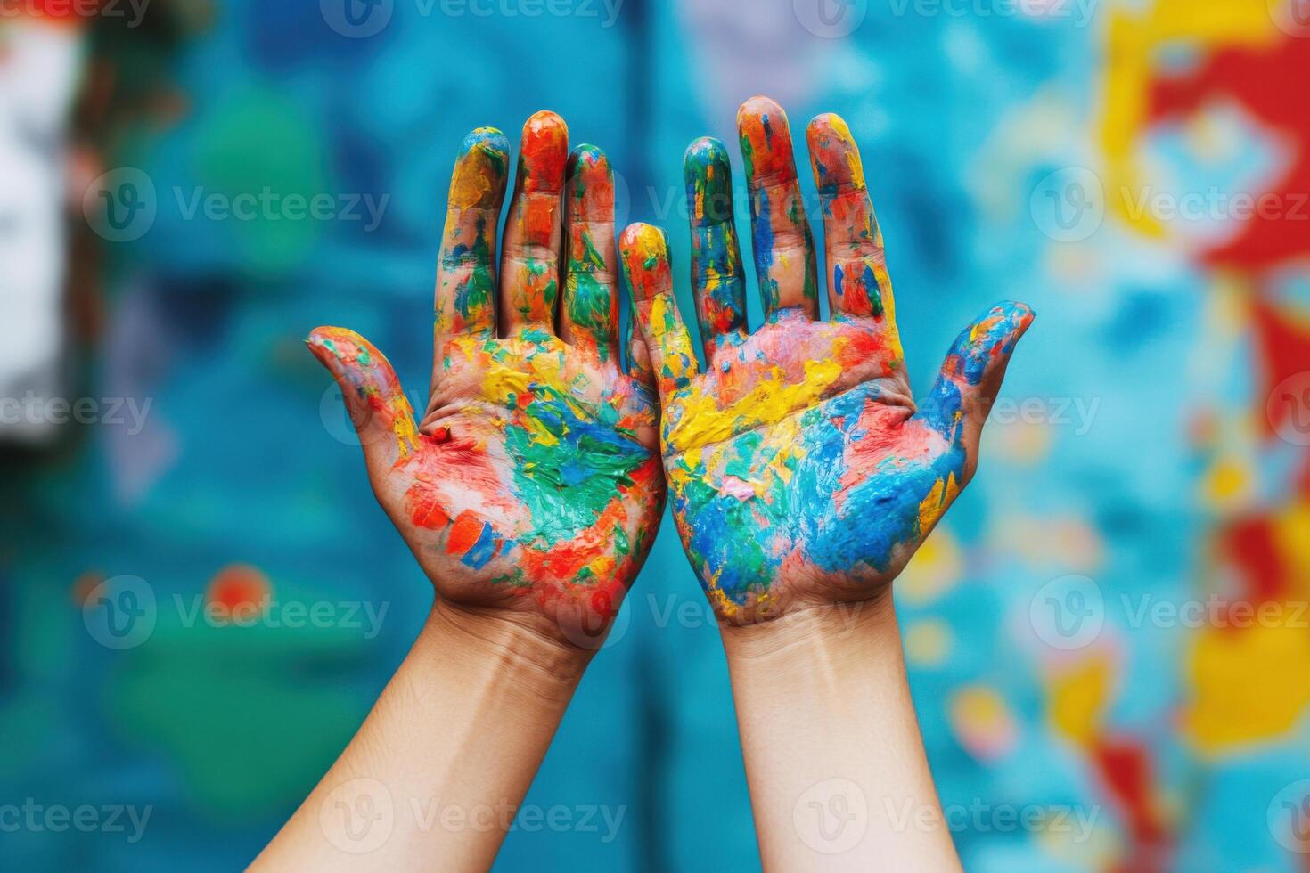 Colorful hands show artistic expression after painting at an outdoor event in a vibrant urban area photo