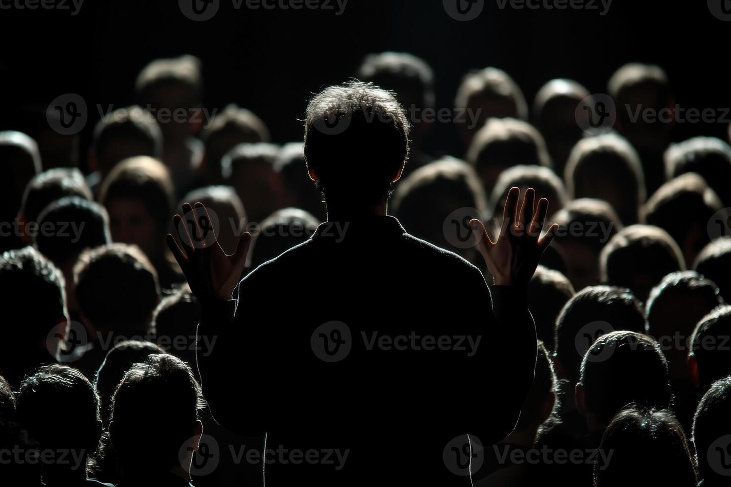 Crowd engages with speaker during a passionate presentation in a dimly lit auditorium photo