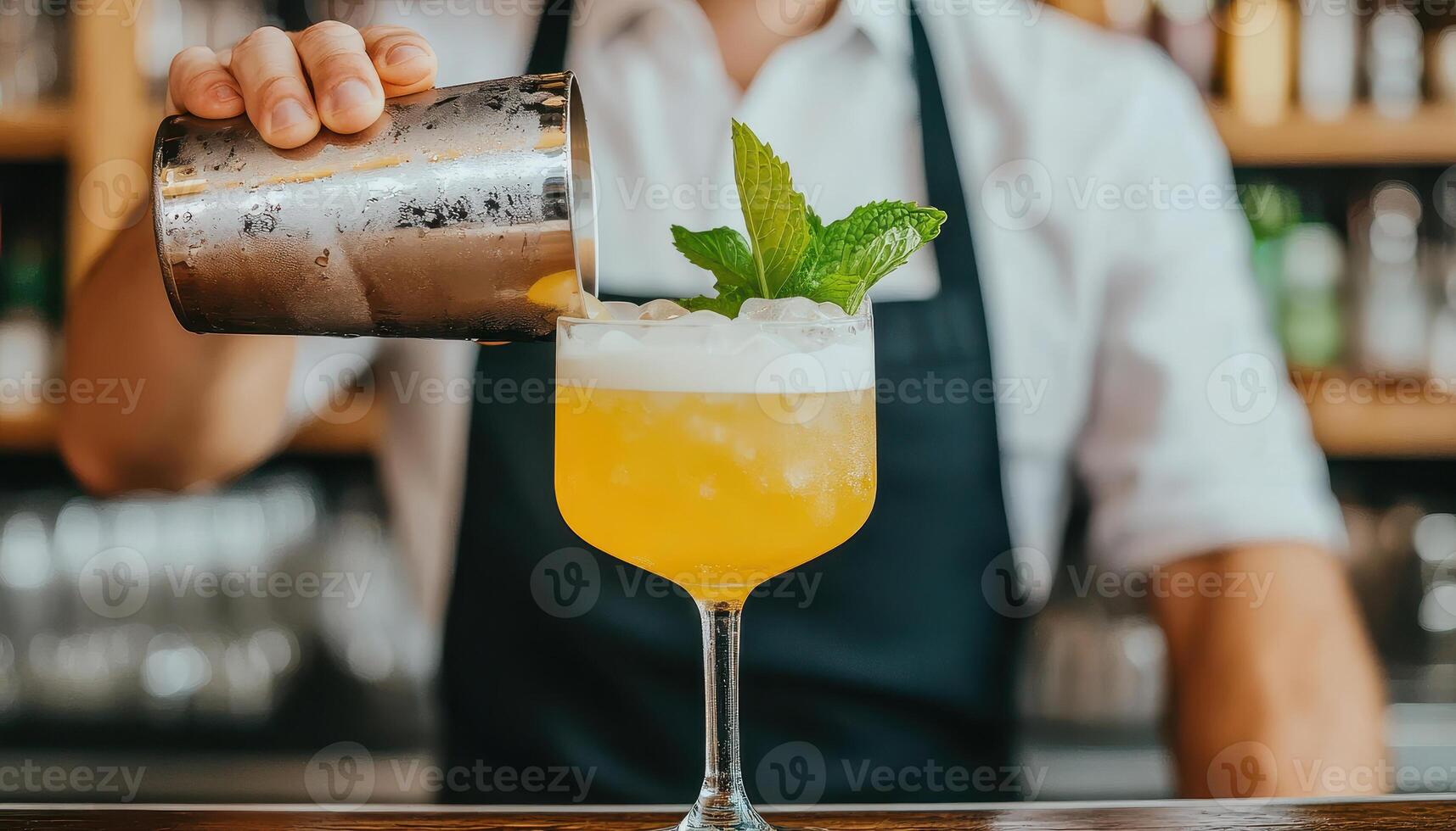 Unique angle showing bartender shaking cocktail with mint garnish, creating refreshing drink. vibrant colors and lively atmosphere enhance experience photo