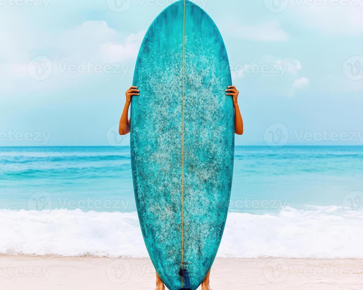woman holding vibrant turquoise surfboard at beach, with waves in background, exuding sense of adventure and joy photo