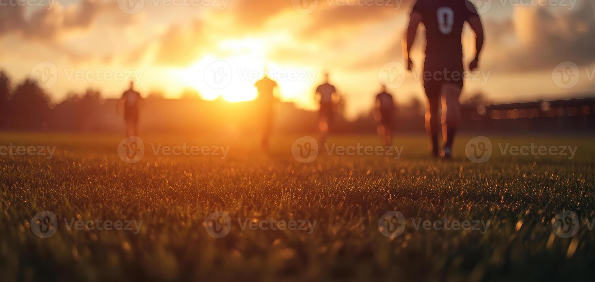 Rugby players warming up on field at sunset, creating vibrant atmosphere photo