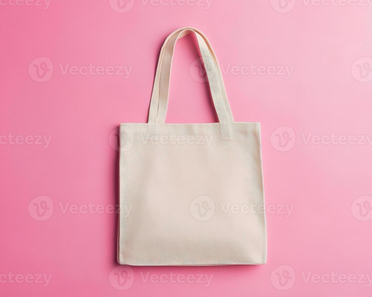 simple and clean image of tote bag lying flat on pink background, showcasing its versatile design and neutral color, perfect for everyday use photo