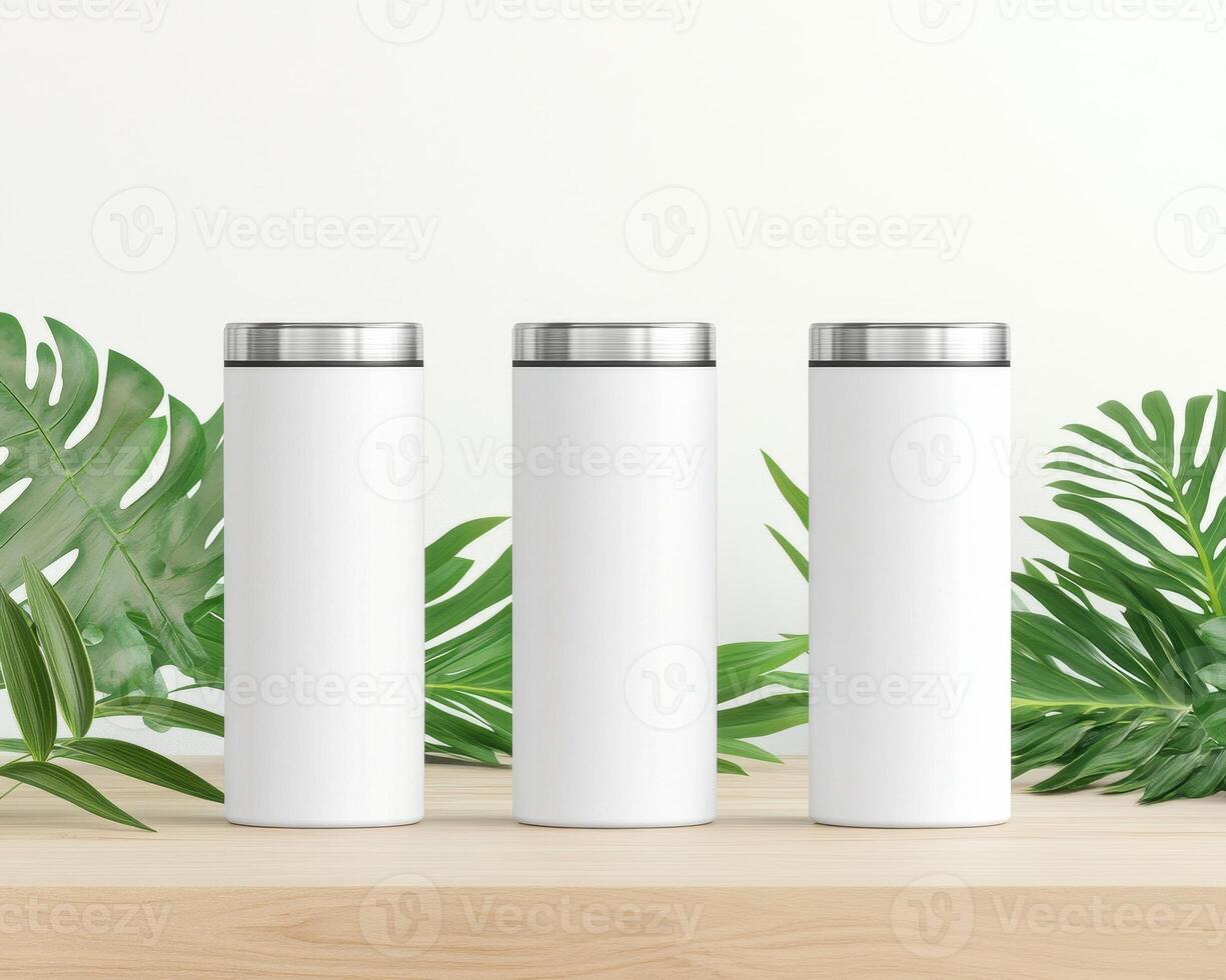 Minimalist design featuring three blank white tumblers surrounded by green leaves, perfect for showcasing branding or personal designs. Ideal for promotional use or product photography photo