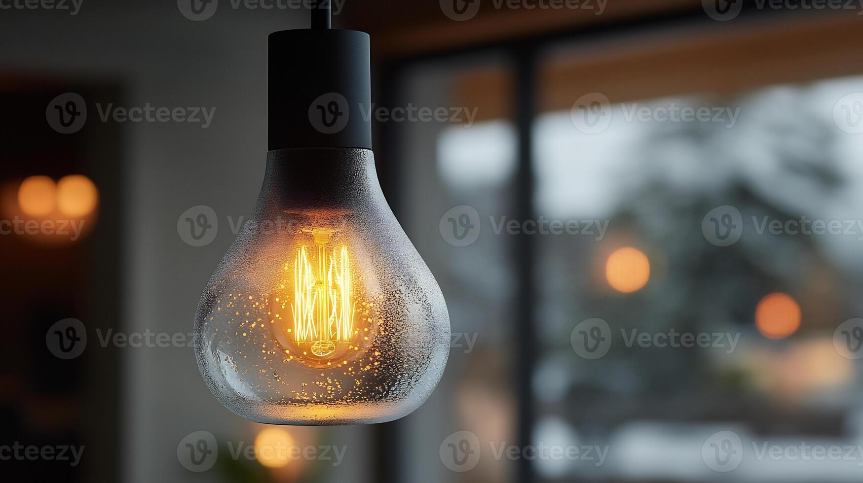 Closeup of glowing bulb inside a pendant lamp with frosted glass spreading soft illumination to highlight clean contemporary lines and minimalist aesthetics photo