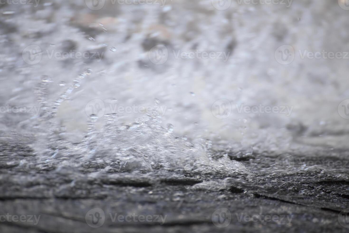 Blurry water spray flowing on paved stone structure photo