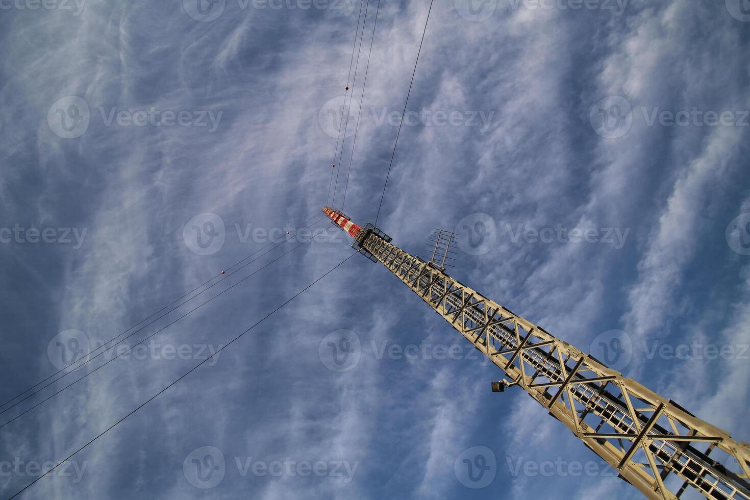 A red and white radio tower in unusual angle photo