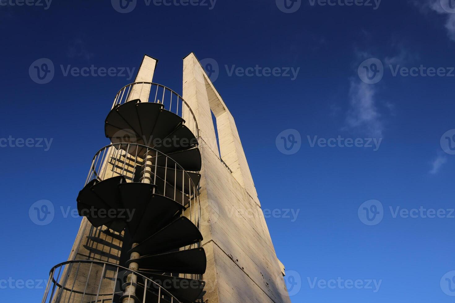 Lookout tower with spiral staircase seen from below. The sky is darkened due to the use of a polarization filter photo