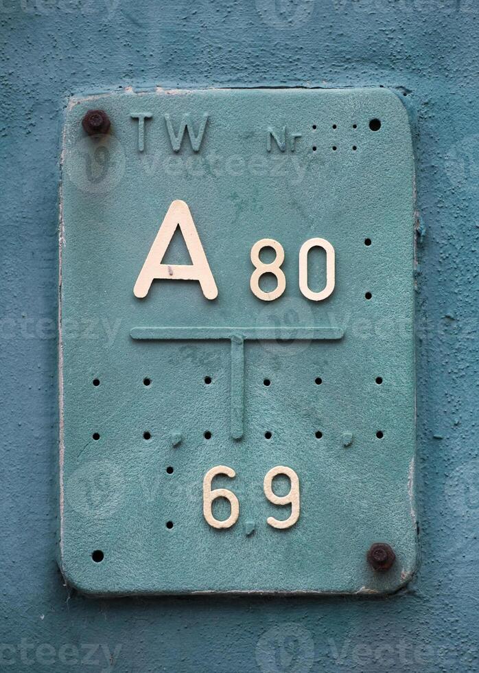 Historic German sign giving the position of the nearest street cap and diameter of the pipe underneath. photo