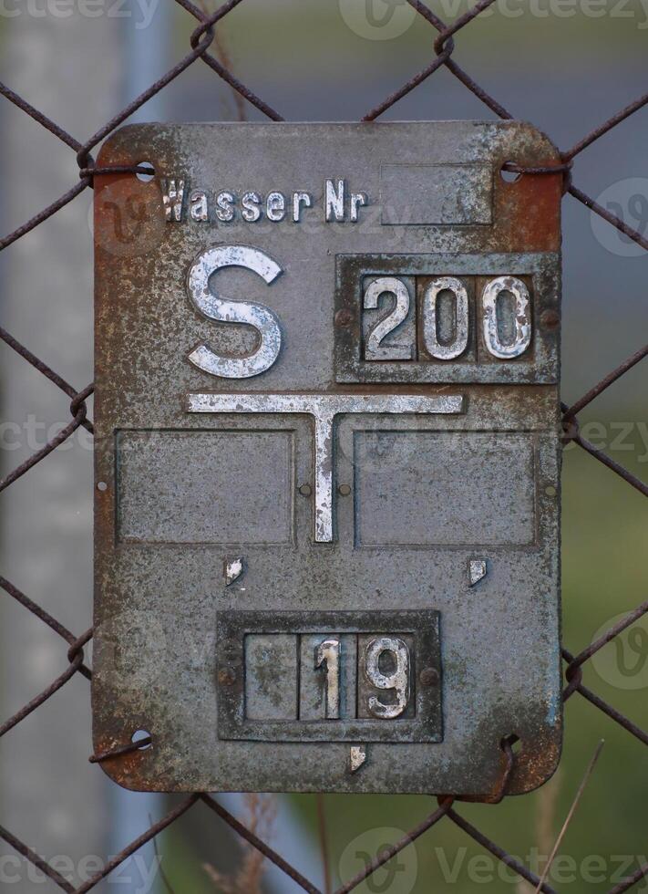 Historical gate valve sign for water supply in Germany. The information on the sign give the type and position of a nearby underground gate valve. photo