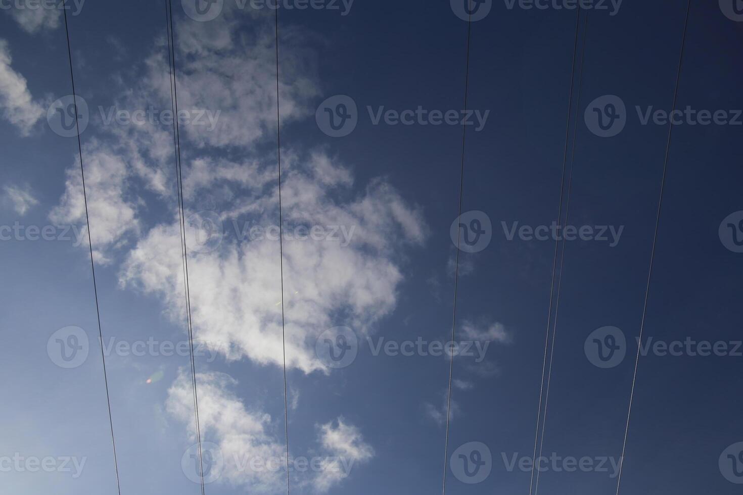 Cables on high voltage power line on a dark blue sky with cloudscape. photo