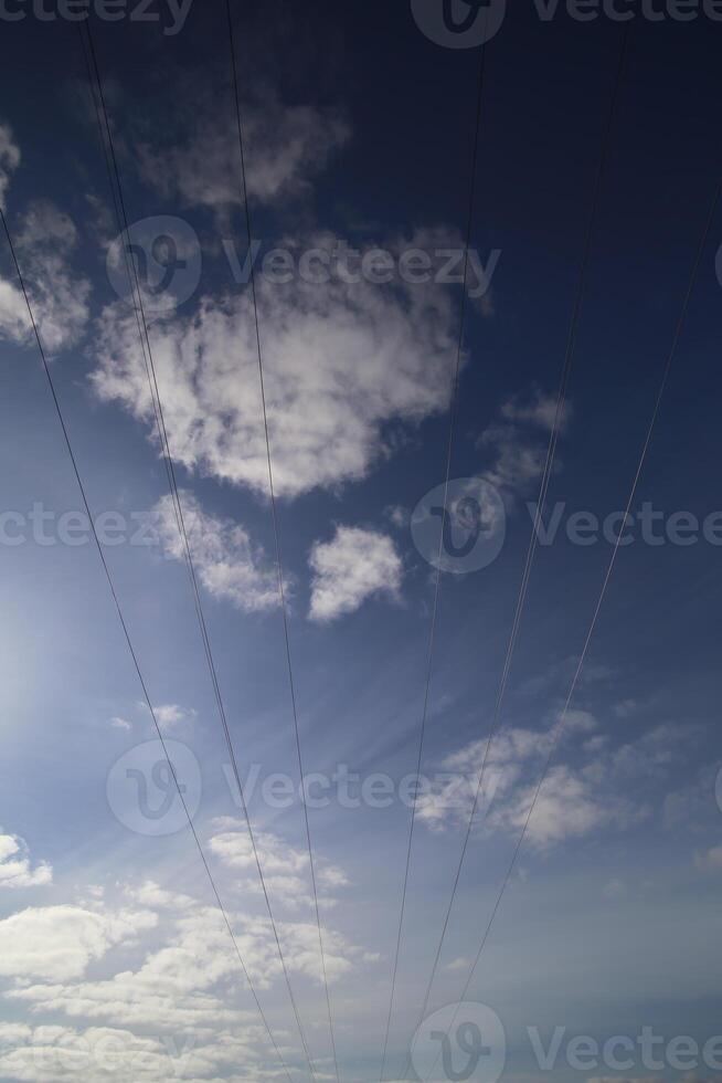 Cables on high voltage power line on a dark blue sky with cloudscape photo