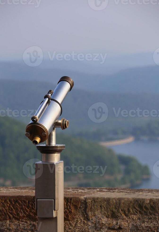 View over the mountains in Hesse, Germany, besides an old-fashioned telescope. photo