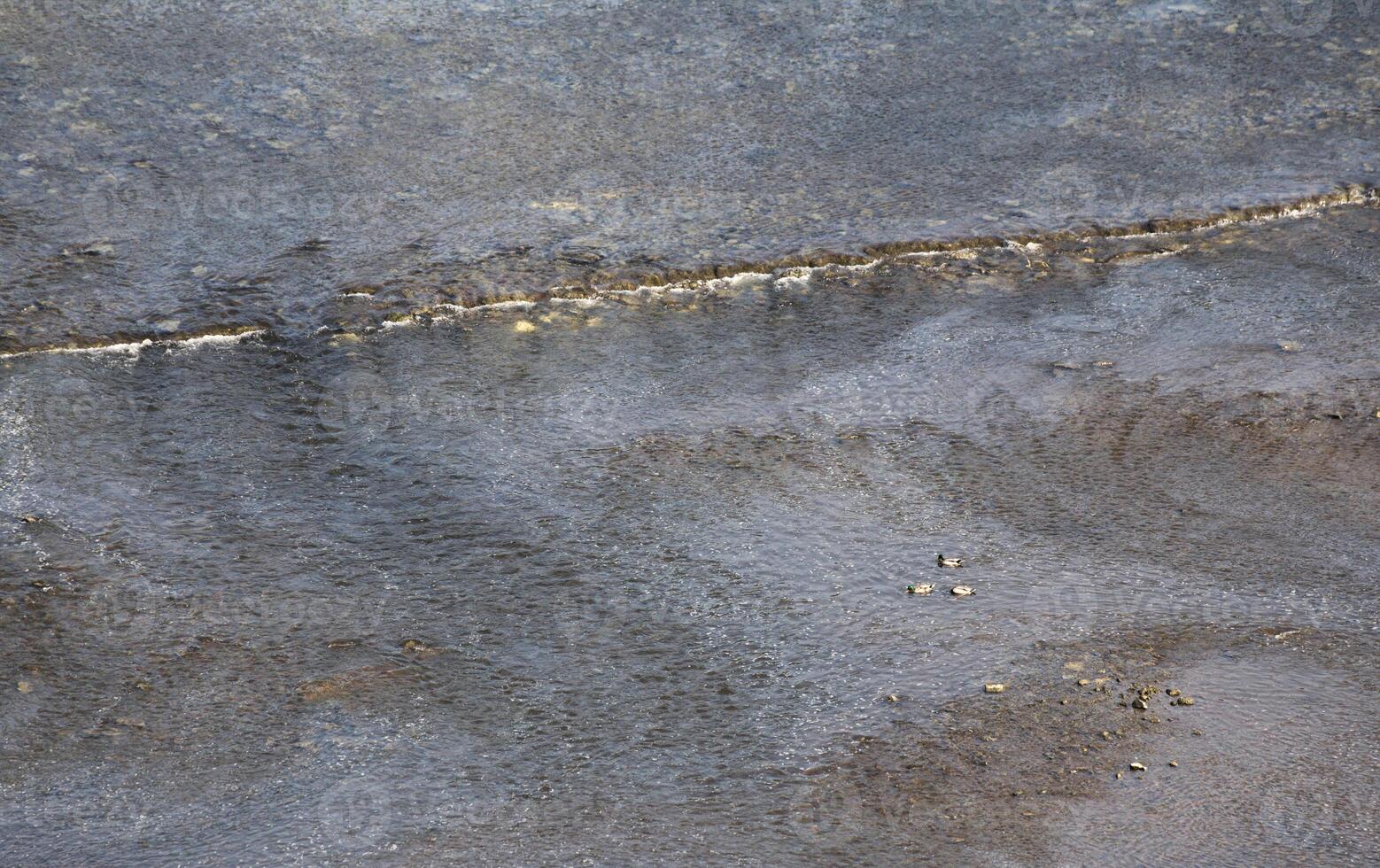 Reflections on a river with rapids on rocks. photo