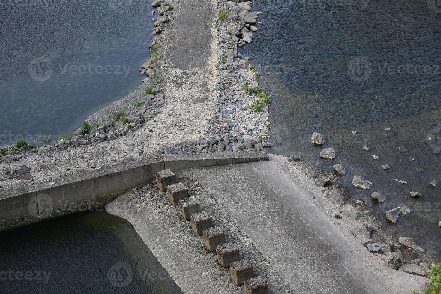 Rock dams with road and water on all sides. photo