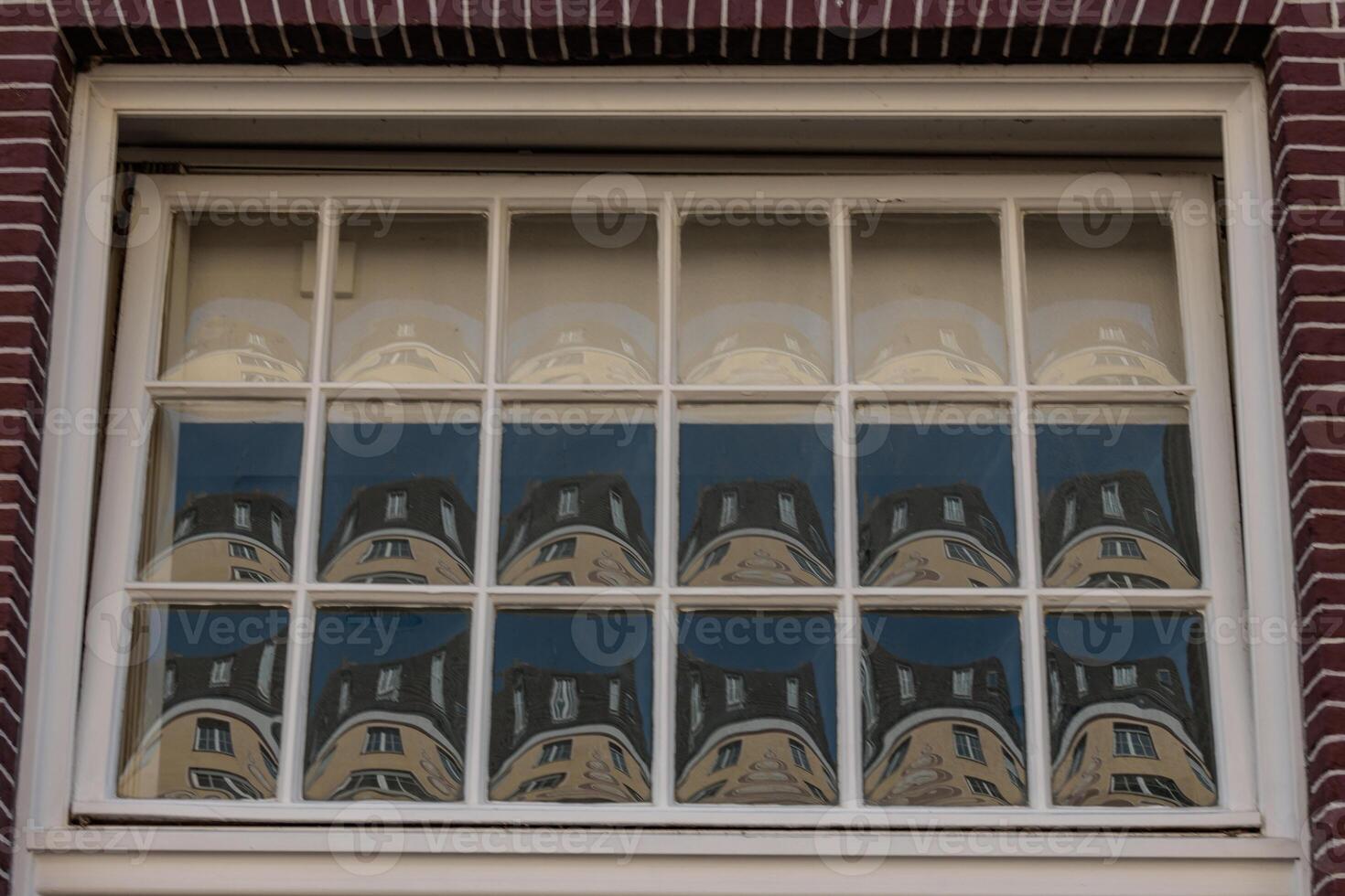 A window with a reflection of a building photo