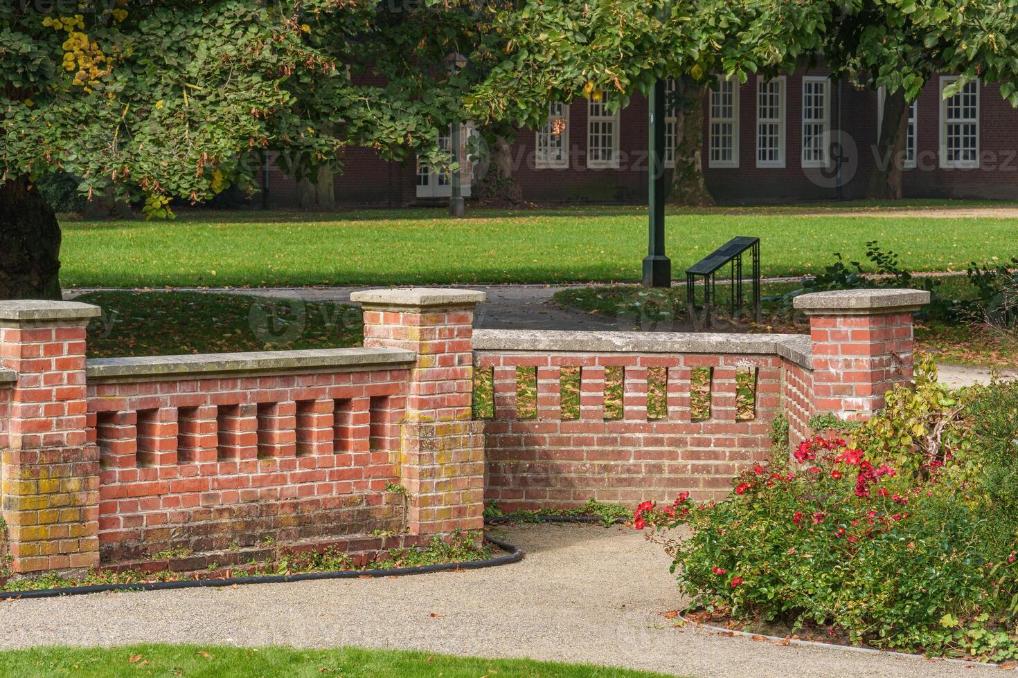 A brick wall with a bench in front of it photo