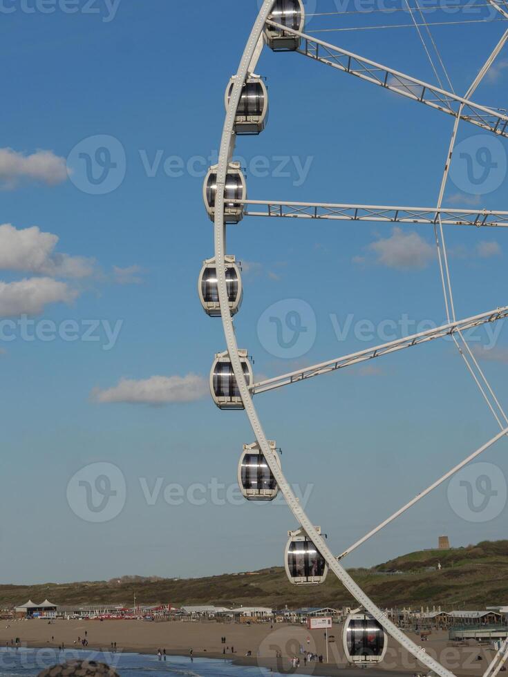 A large white ferris wheel at the beach in holland photo