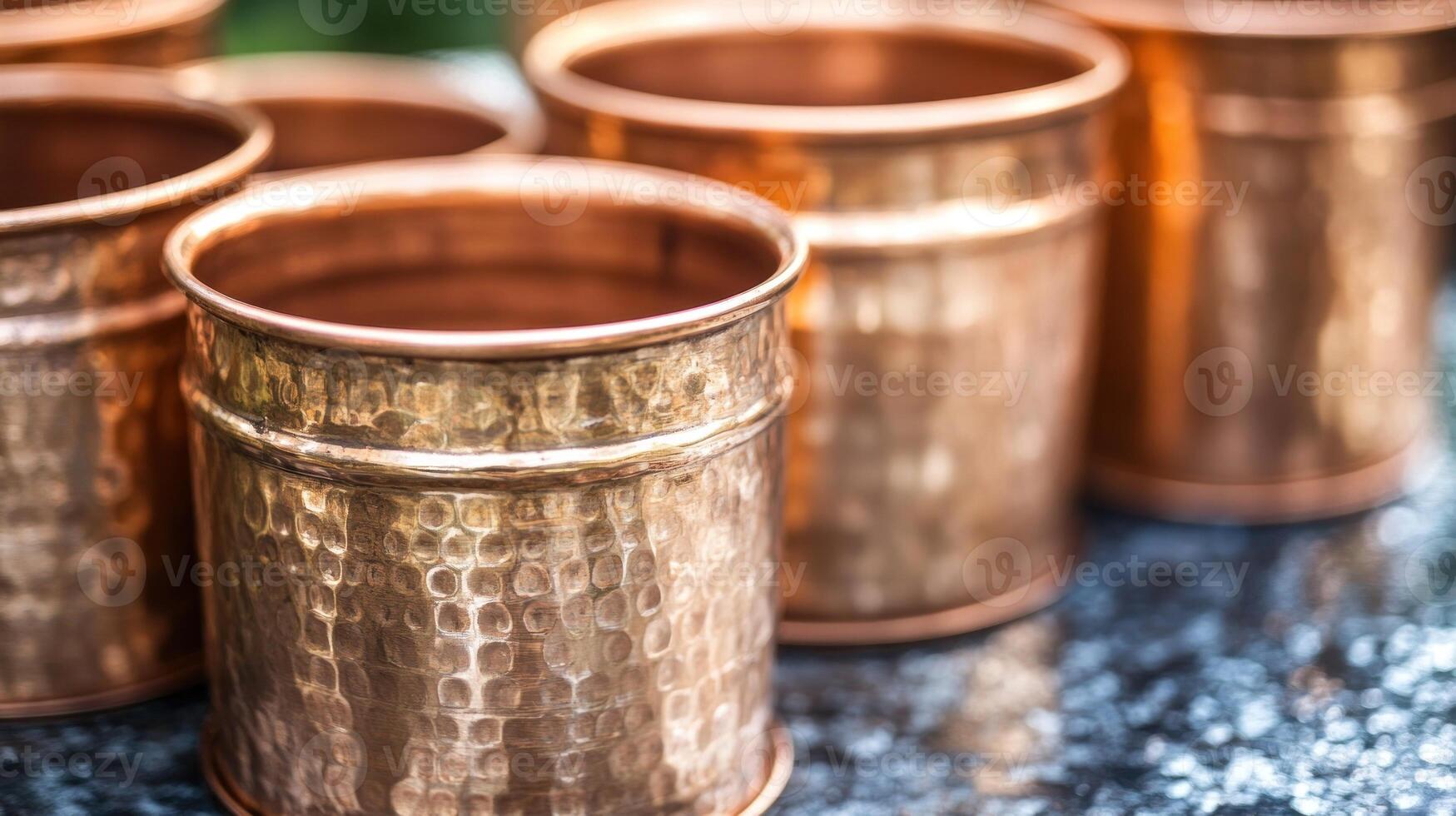 Shiny copper mugs gleam in the sun, highlighting craftsmanship in a peaceful outdoor scene photo