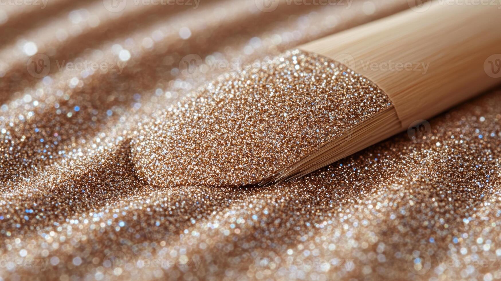 Fine golden particles shimmer on a textured surface, accentuated by a wooden applicator tool nearby photo