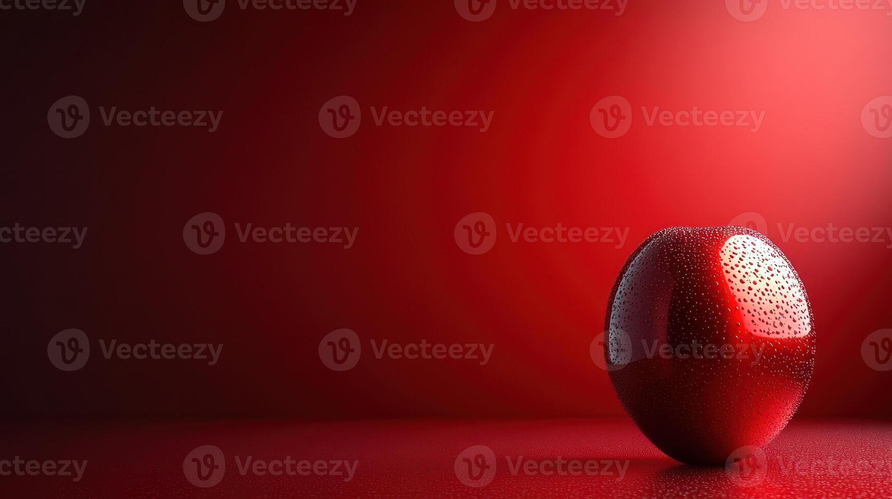 A bright red apple with glistening droplets shines against a rich red background photo