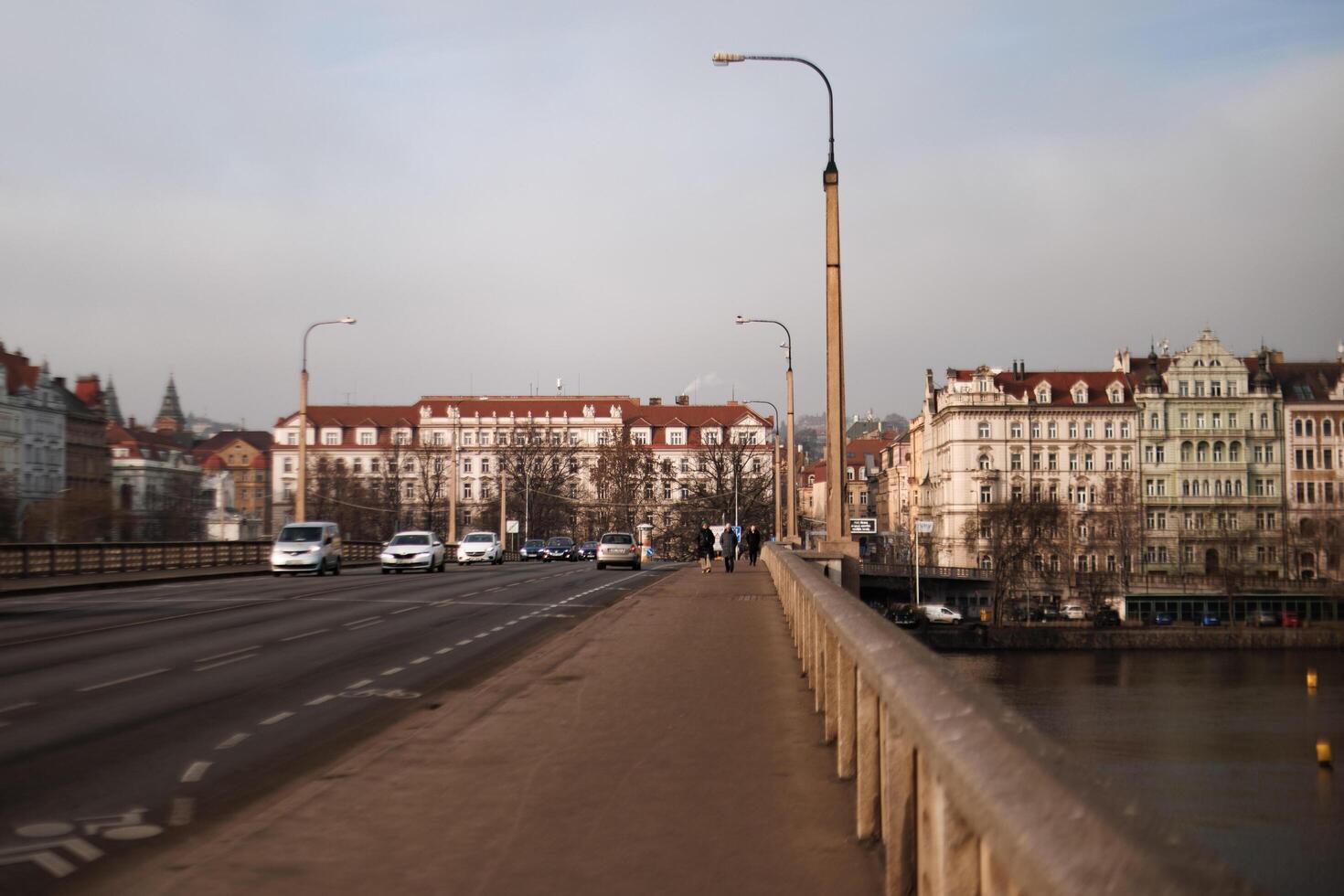 Prague, Czech republic - February 16, 2023 Tourists walking on jirasek bridge with cars passing by photo