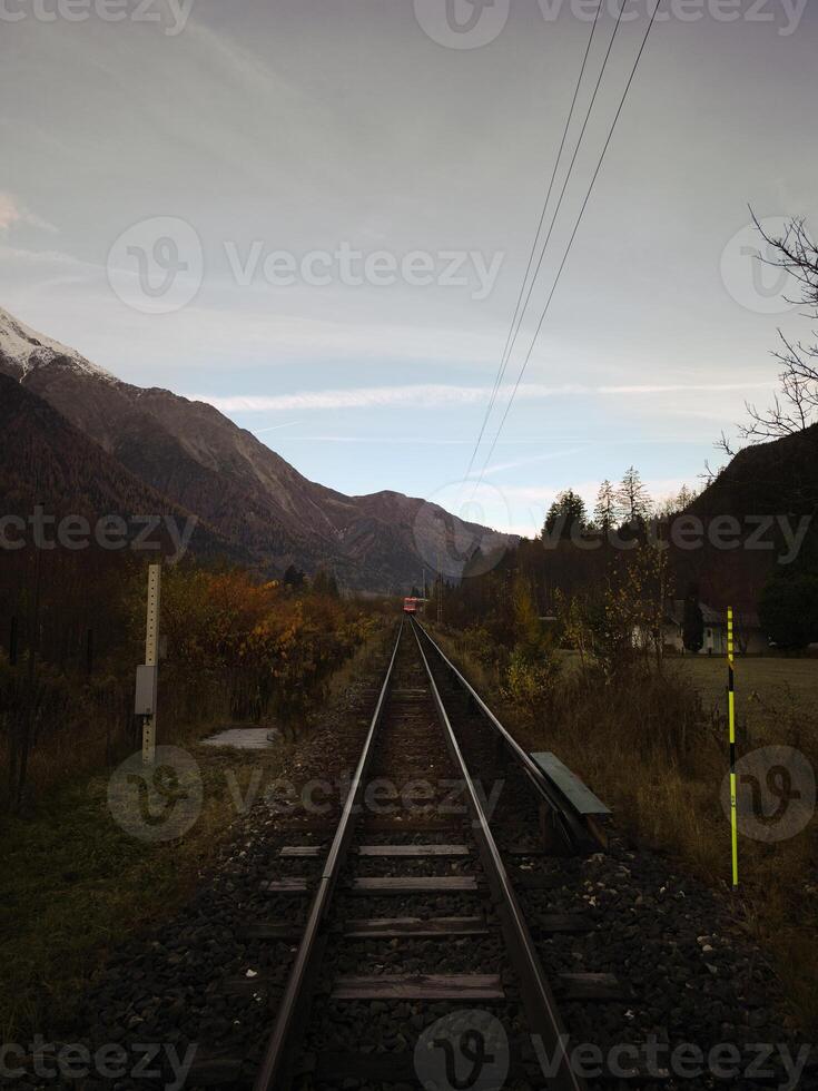 Train approaching on railway in chamonix valley, french alps photo