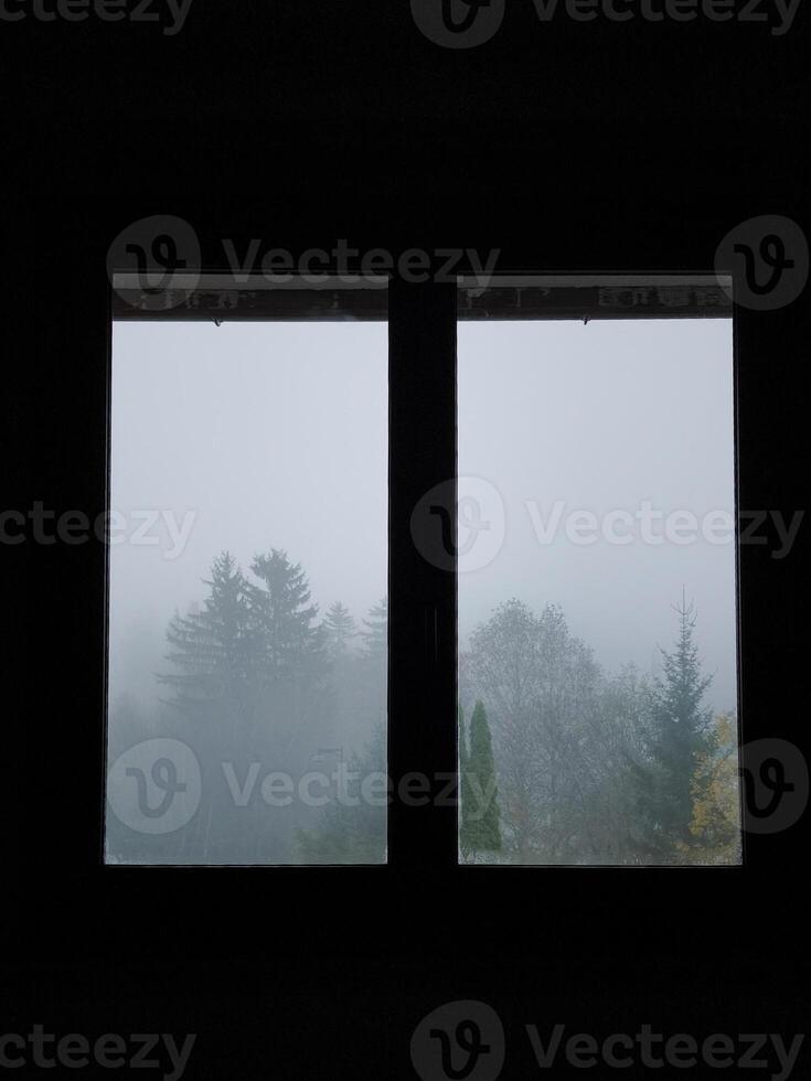 Foggy forest landscape viewed through a window in chamonix, france photo