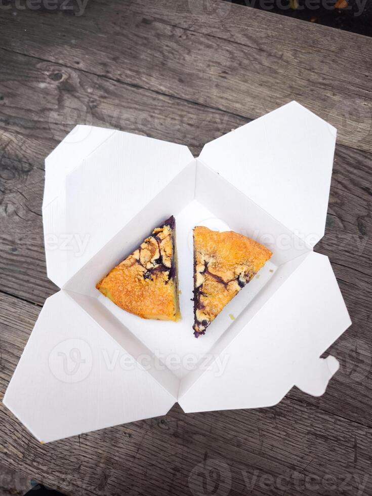 Two slices of blueberry pie resting in white cardboard box on rustic wooden table photo