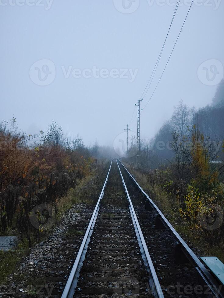 Train tracks disappearing into the fog in chamonix, france photo