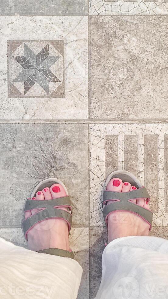 Tourist wearing sandals standing on decorative ceramic tiles after spa procedures in egypt photo