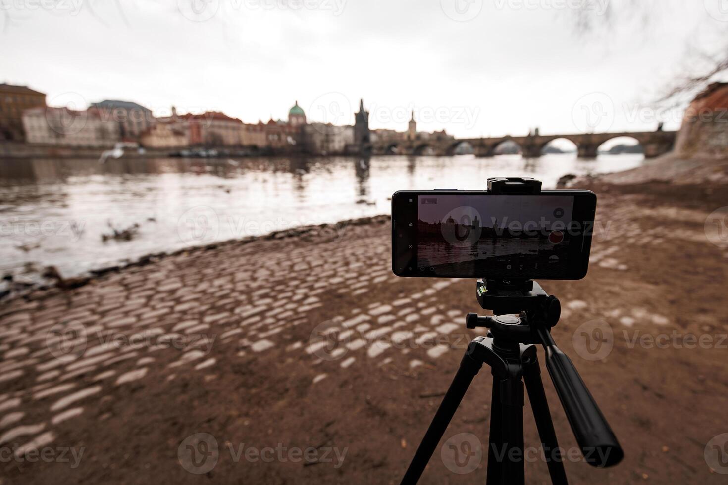 Smartphone recording time lapse of vltava river and charles bridge in prague photo