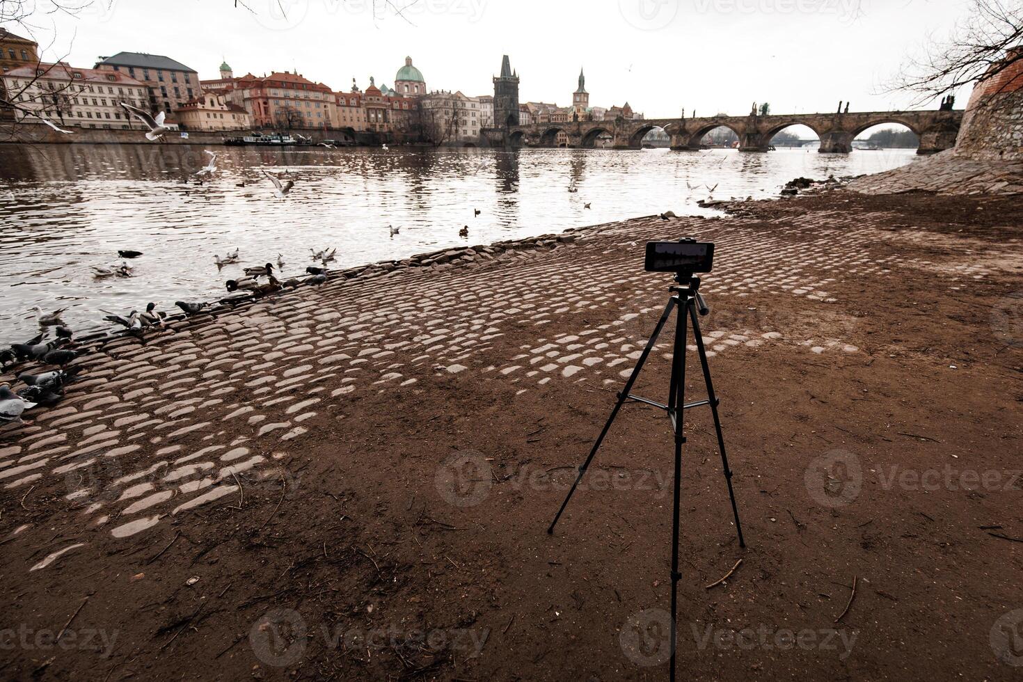Smartphone recording timelapse of vltava river and charles bridge in prague photo