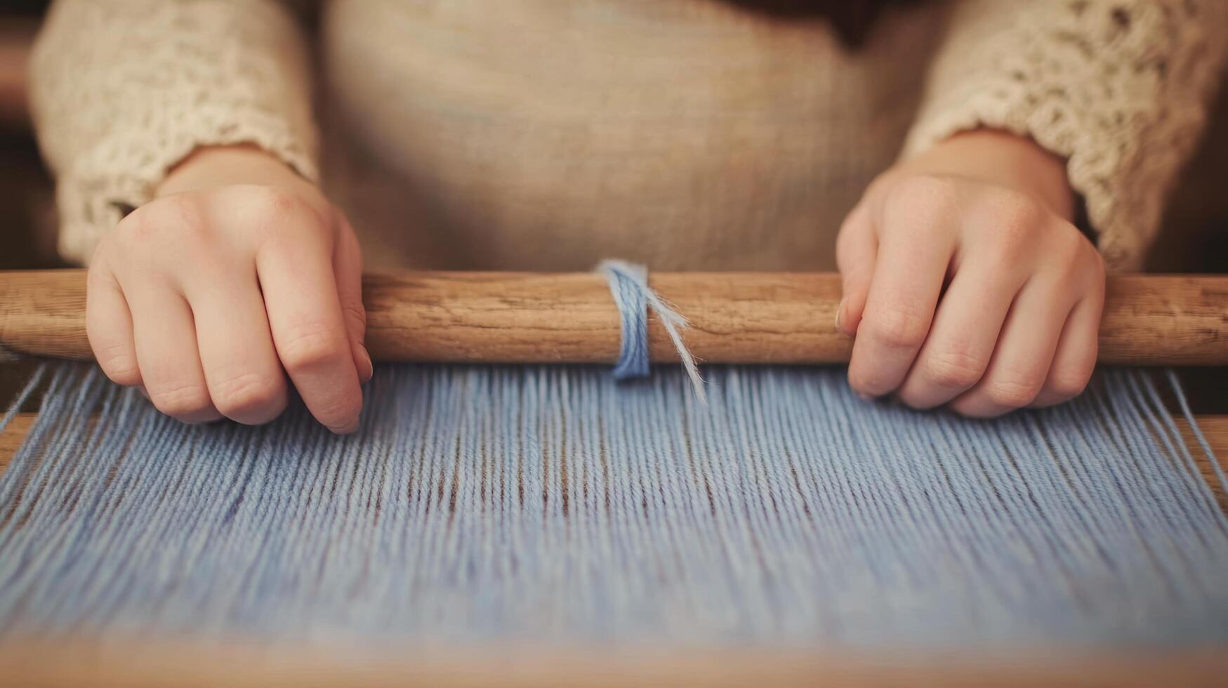 Hands Weaving Blue Threads on a Loom in Traditional Textile Crafting Scene photo