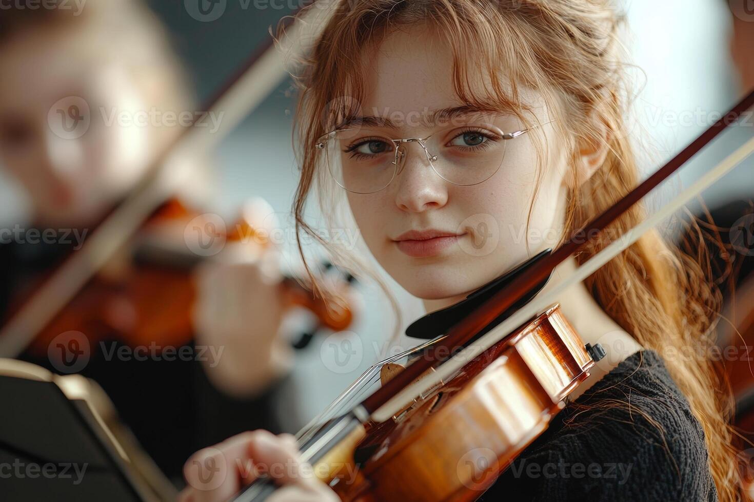 Young violinist performing during a rehearsal, surrounded by fellow musicians in a bright, contemporary practice space photo