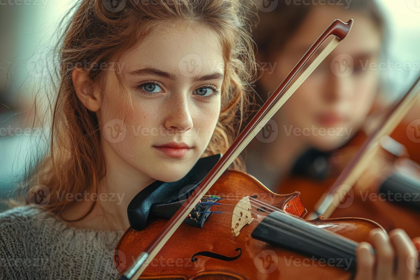 Young violinist focused on her performance while practicing in a music class with classmates indoors photo